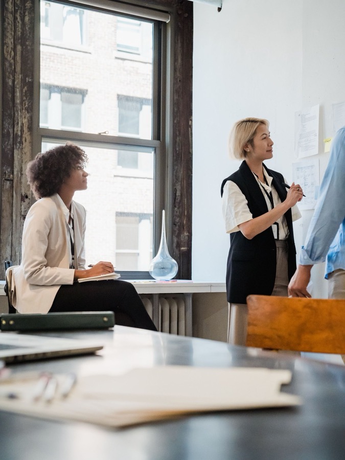 Colleagues discussing work in a bright, modern office